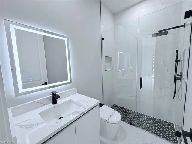Full bathroom with vanity and a marble finish shower