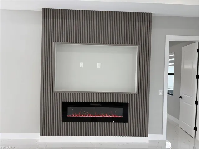 Detailed view of a glass covered fireplace and an accent wall