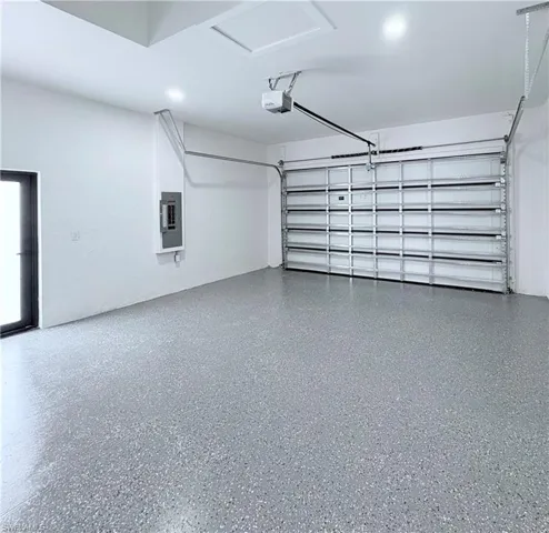 Garage featuring electric panel and a garage door opener