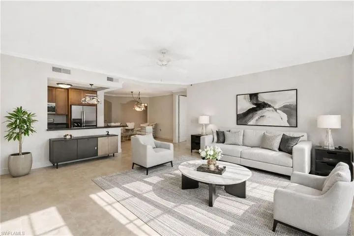 Living area with crown molding, a ceiling fan, and a chandelier