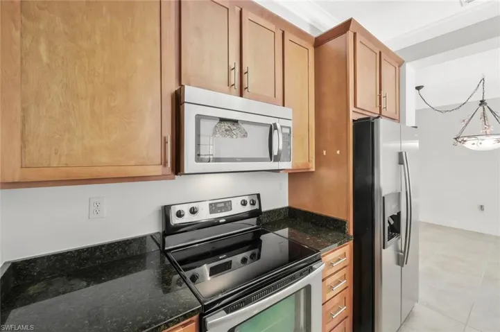Kitchen with granite counter tops, stainless steel appliances and solid wood cabinetry