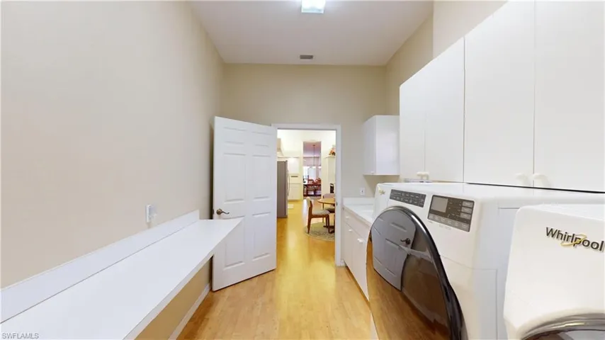 Washroom featuring cabinet space, light wood-style floors, and separate washer and dryer