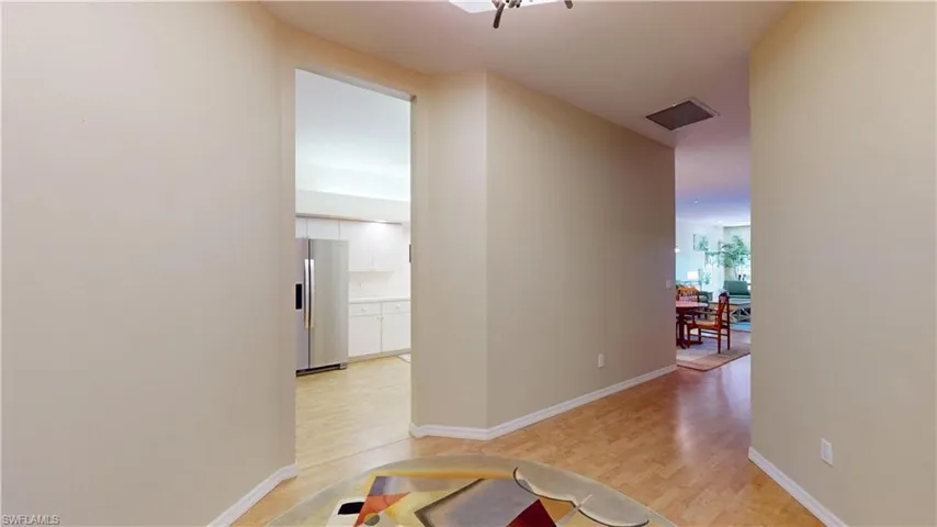 Hallway featuring light wood-type flooring and baseboards