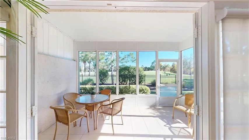 Sunroom / solarium featuring healthy amount of natural light, a textured wall, and view of golf course