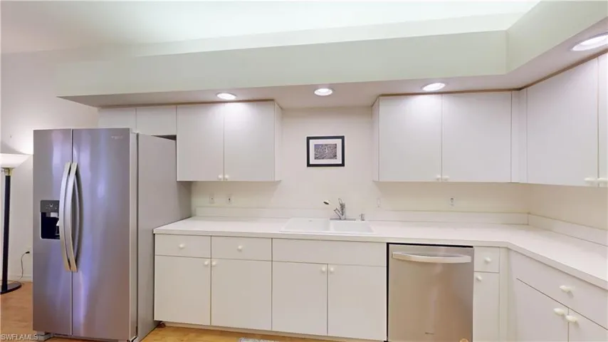 Kitchen with appliances with stainless steel finishes, light countertops, white cabinets, and recessed lighting