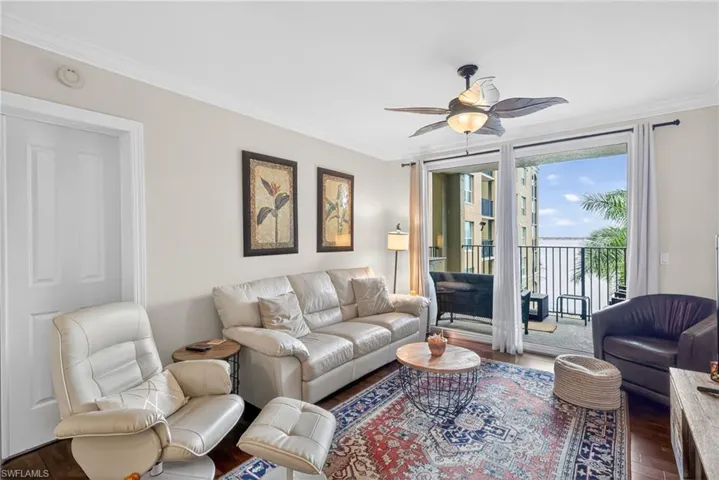Living room featuring crown molding, wood finished floors, and a ceiling fan