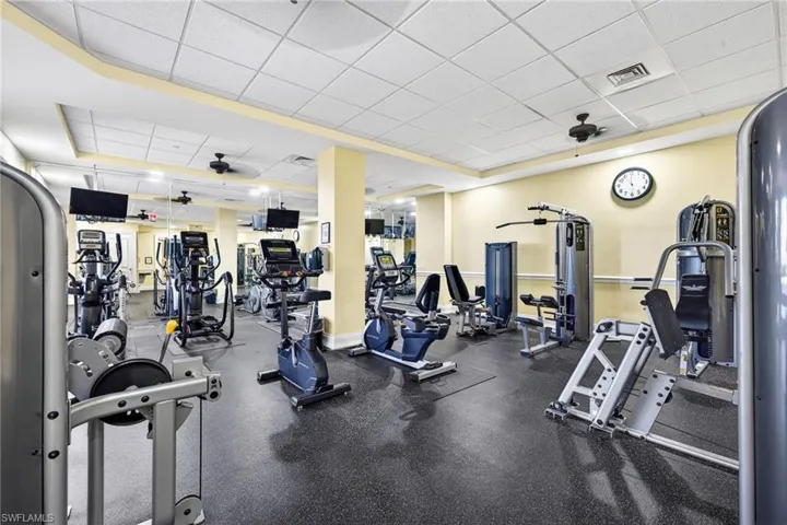 Gym featuring a ceiling fan and a drop ceiling