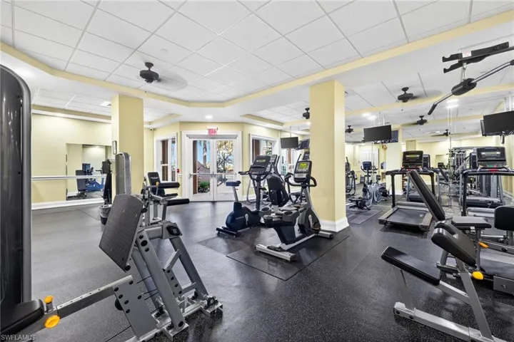 Workout area featuring a ceiling fan and a paneled ceiling