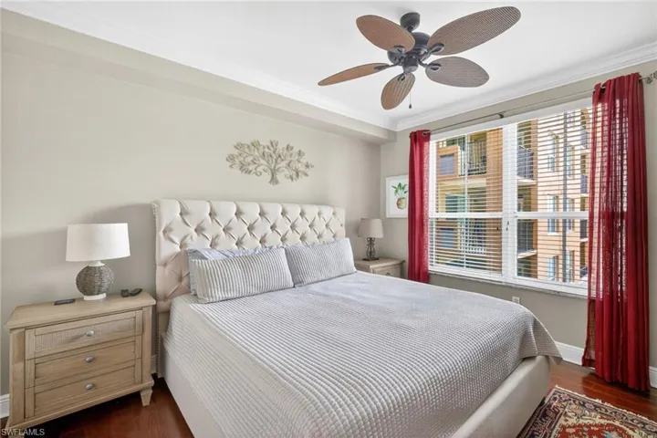 Bedroom featuring dark wood-type flooring, a ceiling fan, and ornamental molding