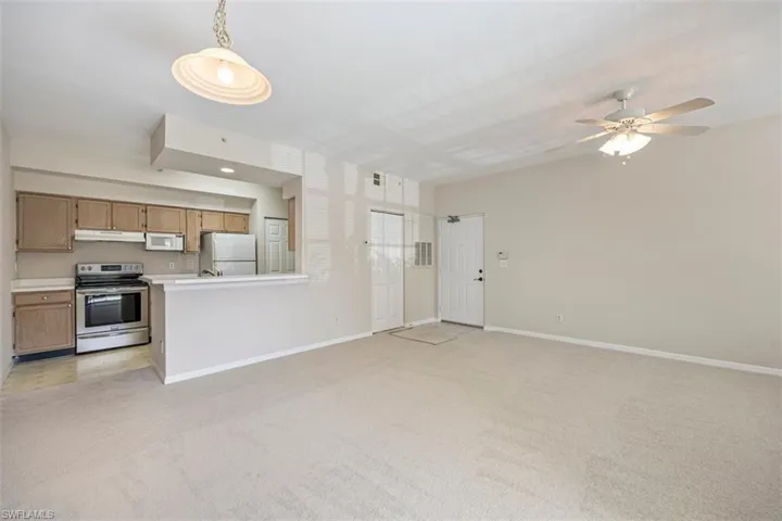 Unfurnished living room with light colored carpet and a ceiling fan