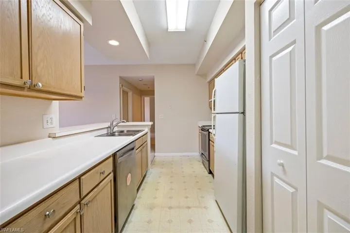 Kitchen with appliances with stainless steel finishes, light flooring, light countertops, and recessed lighting