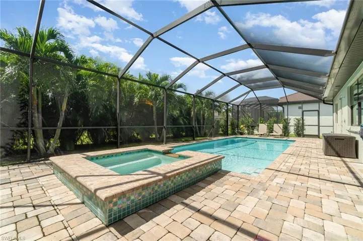 View of pool featuring screen enclosure, an in ground pool & hot tub