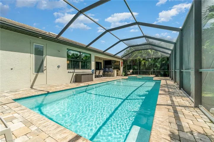 View of pool featuring screen enclosure.