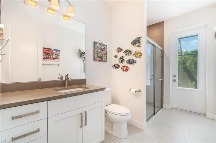 Guest bathroom with walk in shower, vanity, and toilet