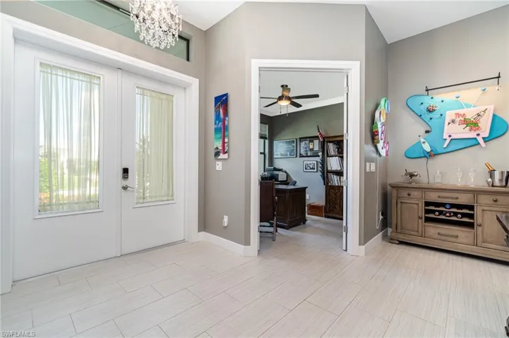 Entrance foyer featuring french doors and ceiling fan with notable chandelier