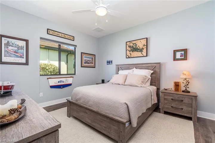 Guest bedroom featuring wood floors, walk in closet and ceiling fan
