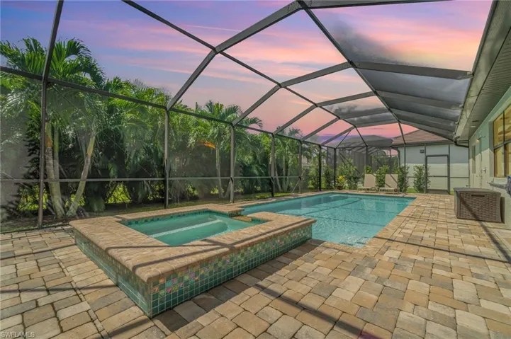 Pool at dusk with an in ground hot tub