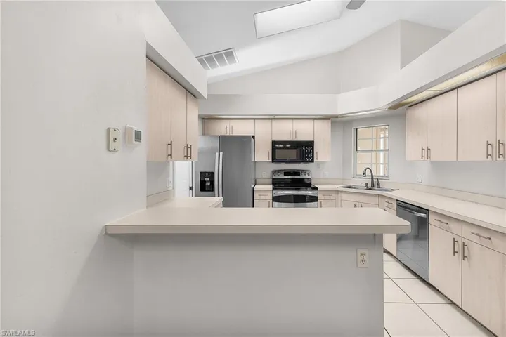 Kitchen features a breakfast bar next to the dining area.