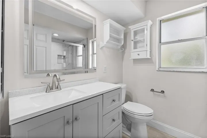 The guest Bathroom has been updated with a new vanity, a new modern mirror that lights up and de-fogs, and a glass-enclosed shower with river rock shower floor tile.