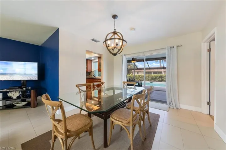 Dining room featuring a chandelier, baseboards, light tile patterned floors, and visible vents