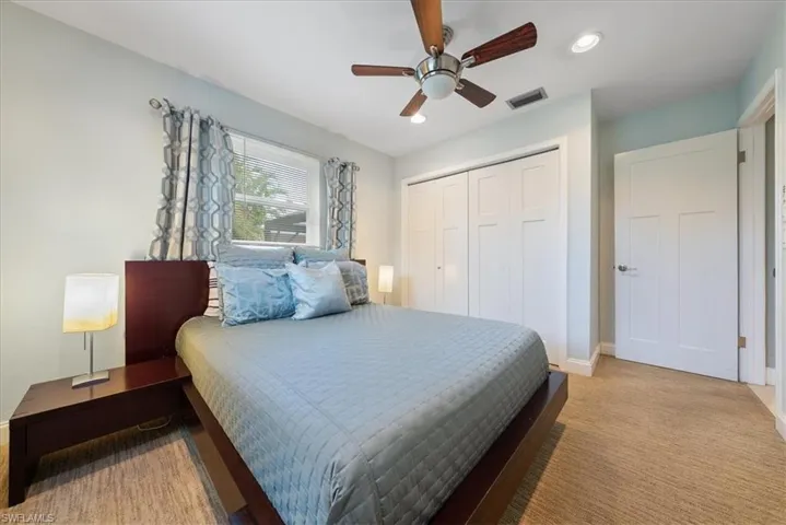 Carpeted bedroom with a ceiling fan, a closet, visible vents, baseboards, and recessed lighting