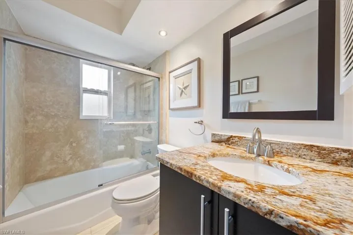 Bathroom featuring vanity, toilet, recessed lighting, and enclosed tub / shower combo