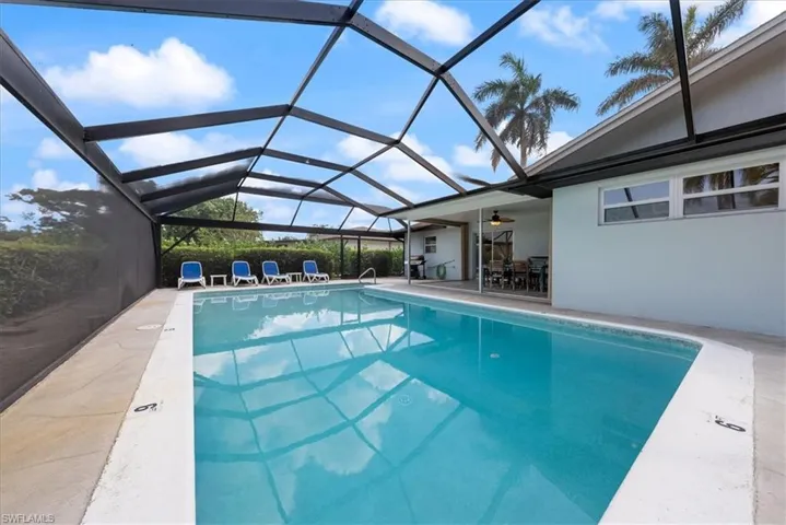 Pool featuring glass enclosure, a patio, and ceiling fan