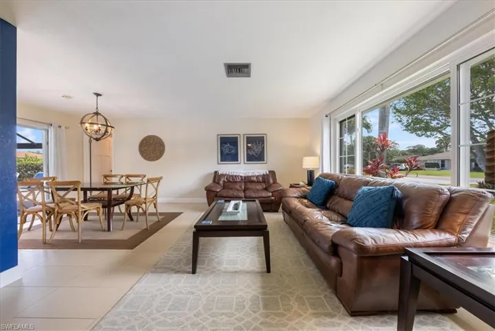 Living area with a chandelier, visible vents, baseboards, and light tile patterned flooring