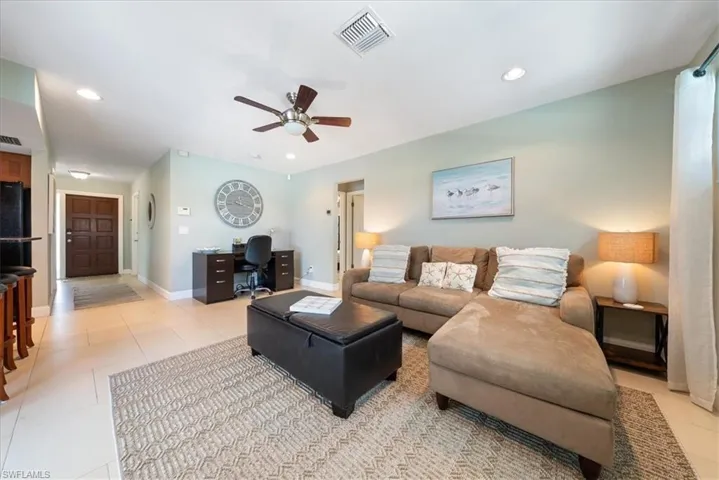 Living area with a ceiling fan, visible vents, baseboards, light tile patterned flooring, and recessed lighting