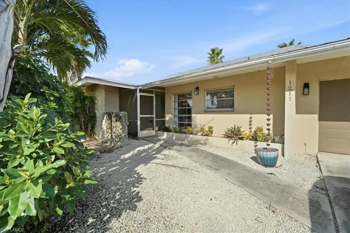Entrance to property featuring stucco siding and a sunroom