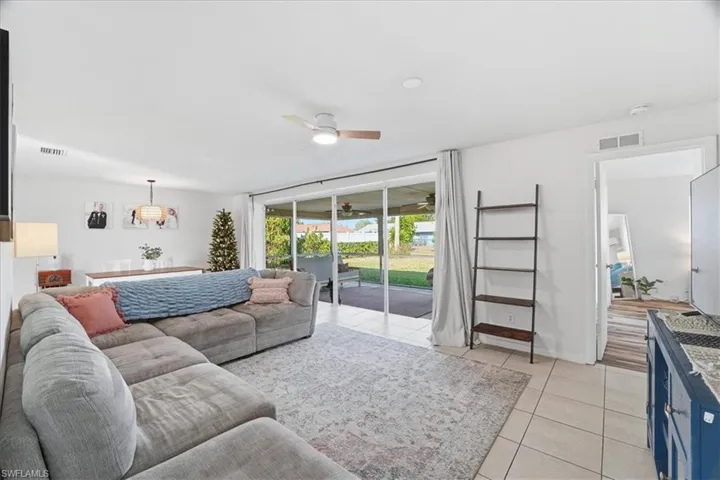 Living room with ceiling fan and light tile patterned floors