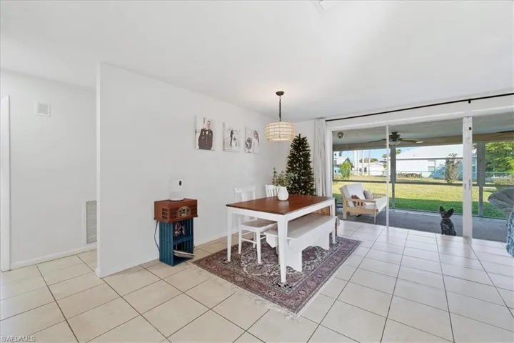 Dining space with light tile patterned floors and a ceiling fan