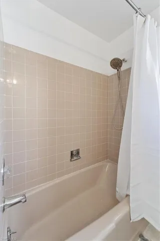 Bathroom featuring shower / bathtub combination with curtain