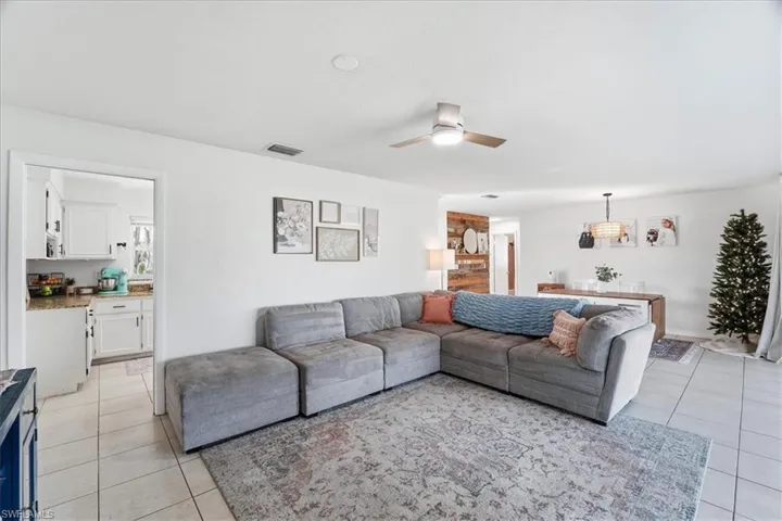 Living room with light tile patterned floors and ceiling fan