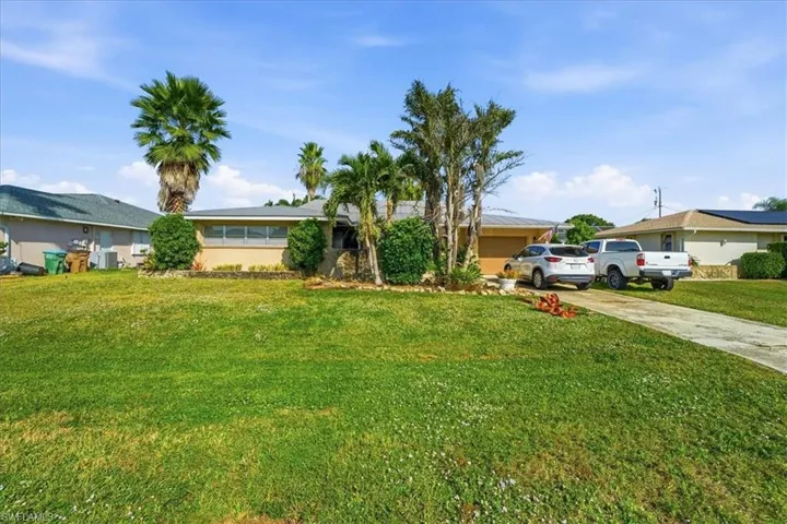 Single story home featuring driveway and a front lawn