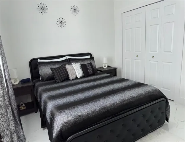 Bedroom with a closet and marble finish floor