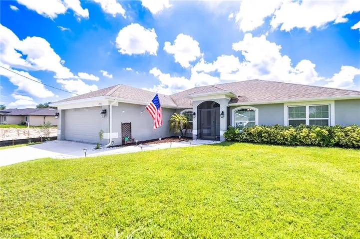 View of front of property featuring a front yard and a garage