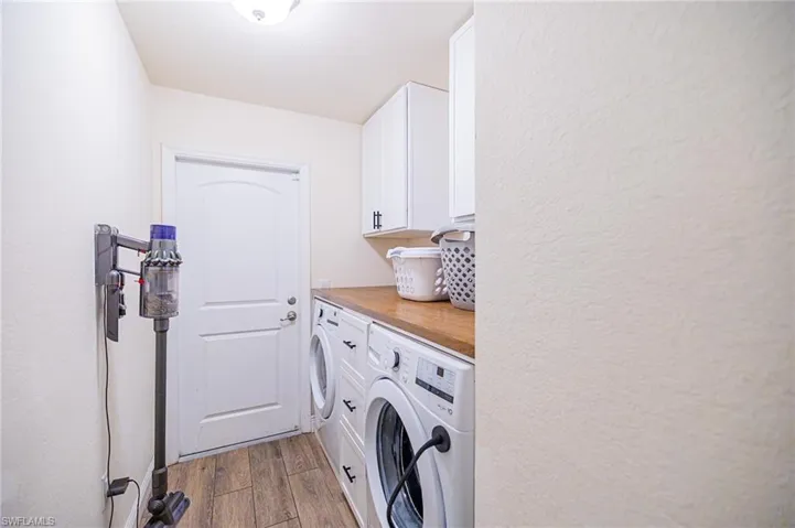 Laundry room featuring cabinets, light wood-type flooring, and washing machine and dryer