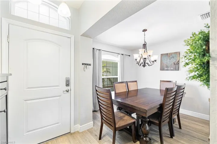 Dining space with a notable chandelier and light wood-type flooring