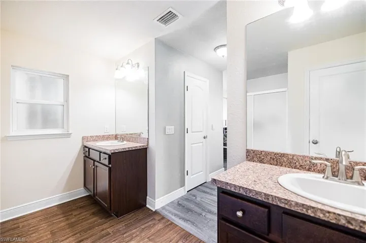 Bathroom featuring vanity, a shower with door, and hardwood / wood-style floors