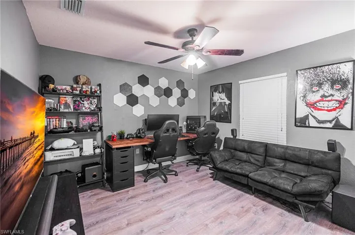 Home office with ceiling fan and light hardwood / wood-style floors