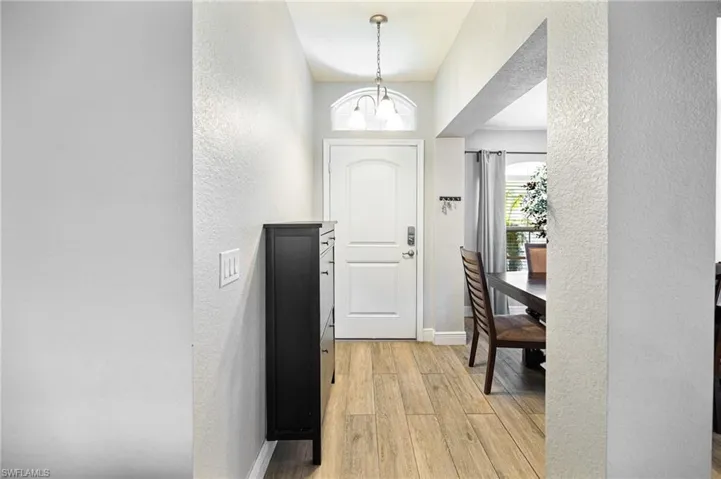 Foyer entrance with a chandelier and light hardwood / wood-style floors