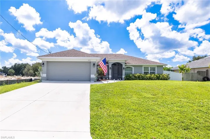 Single story home featuring a garage and a front yard