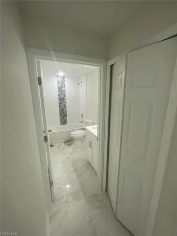 Full bathroom featuring shower / bath combination with curtain, toilet, and vanity