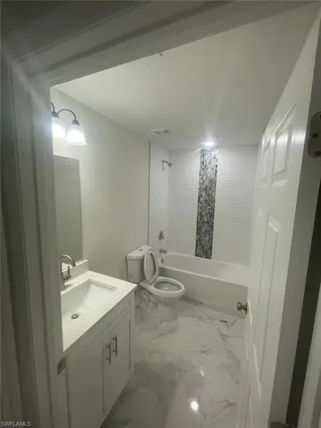 Full bathroom featuring vanity,  shower combination, and toilet