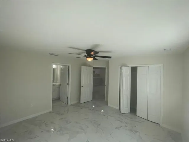 Unfurnished bedroom with a closet, ceiling fan, and ensuite bathroom