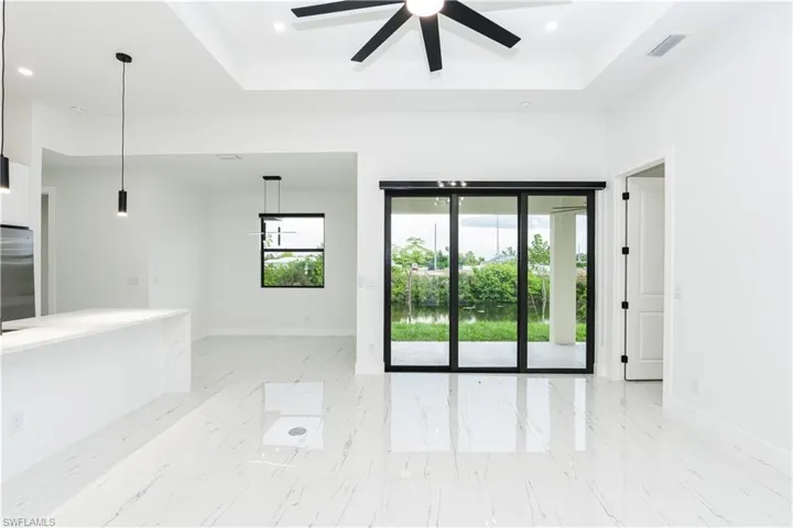 Spare room featuring a raised ceiling, light marble finish flooring, and recessed lighting
