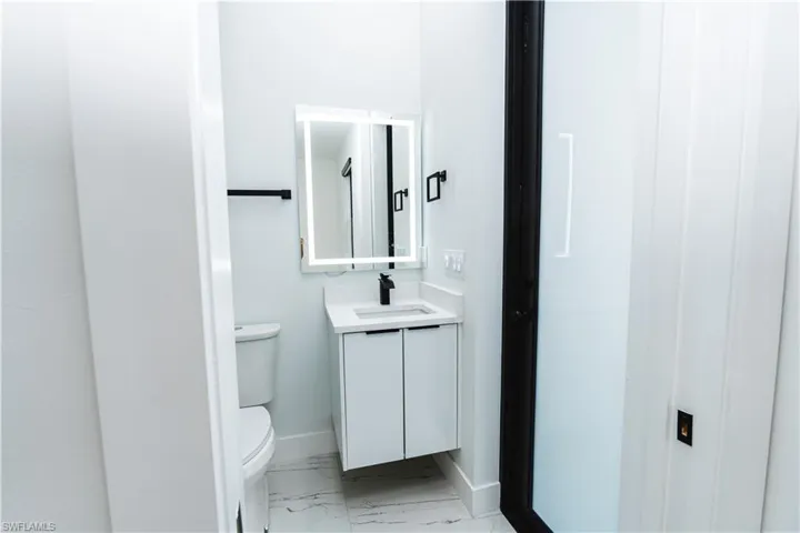 Half bathroom with vanity and light marble finish flooring