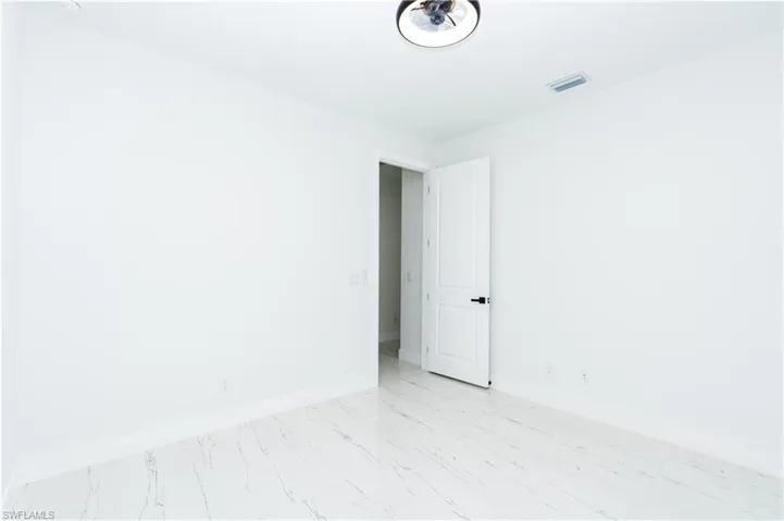 Spare room with baseboards and light marble finish floors