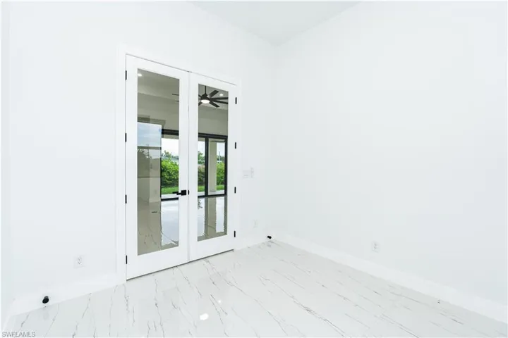 Spare room featuring french doors and light marble finish floors